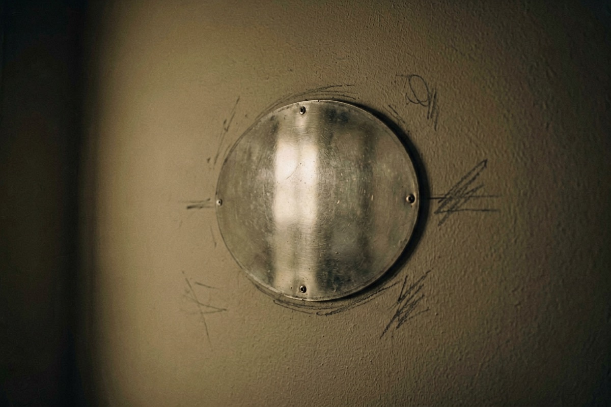An oval patch of hard reflected light on an interior wall, pencil marks beside it (AI-generated illustration)
